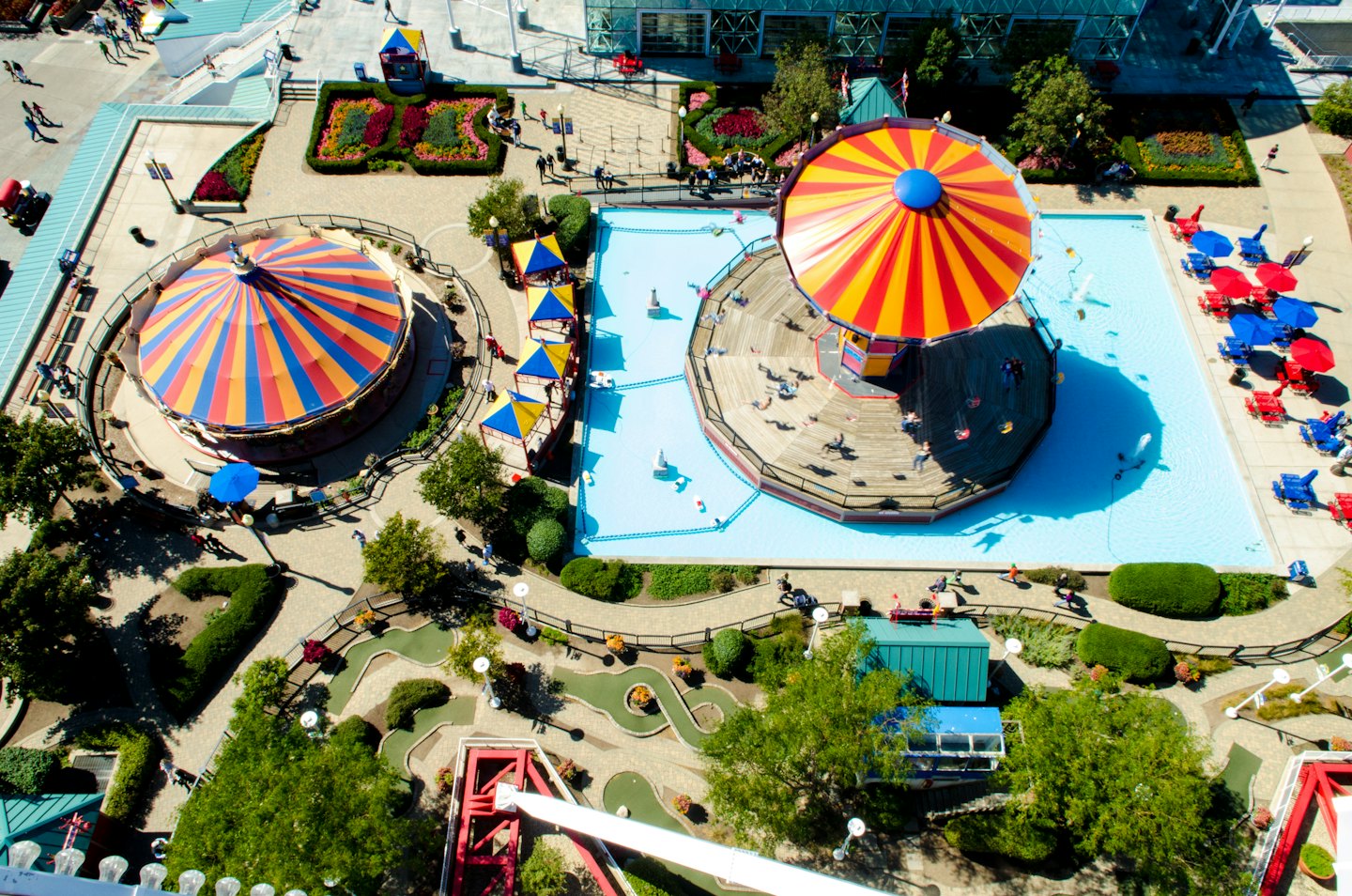 Vue aérienne d'un parc d'attractions animé avec des carrousels et des attractions aquatiques.